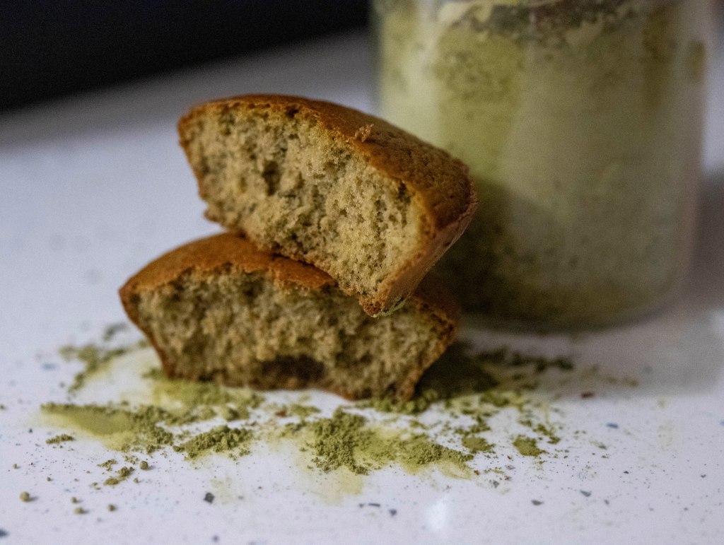 Cupcake into pieces over a matcha and next to a jar with matcha